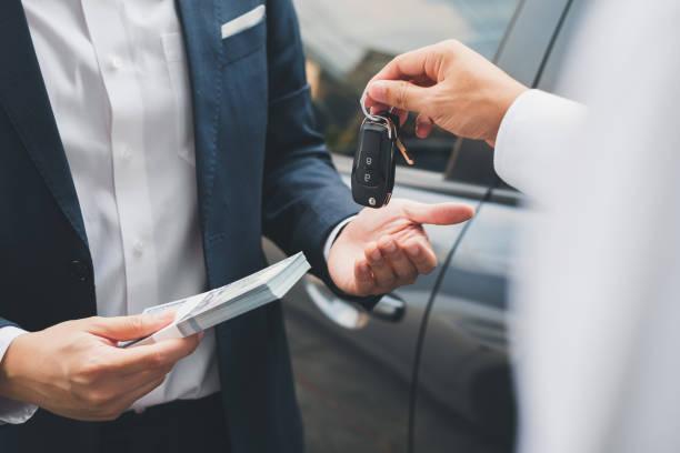 Happy customer receiving car keys from leasing consultant, starting their leasing journey