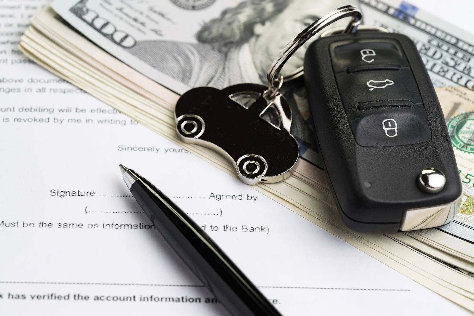 An agreement to refinance a car loan, the car keys, and a pen.
